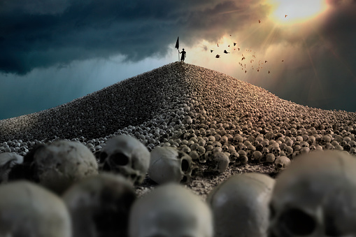 Mountain of human skulls with crows flying over